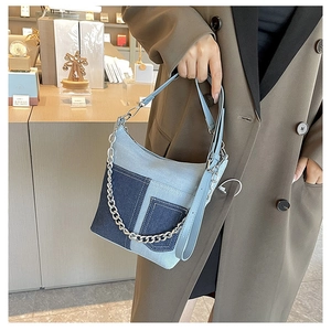 Detailed shot of retro denim patchwork handbag with thick silver metal chain and strap