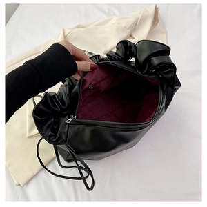 Detail view of the black cloud bag showing dark red lining and internal zipper pocket