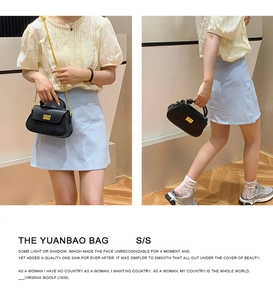 Detail of The Yuanbao Bag showing lychee grain leather, gold chain, and metal clasp