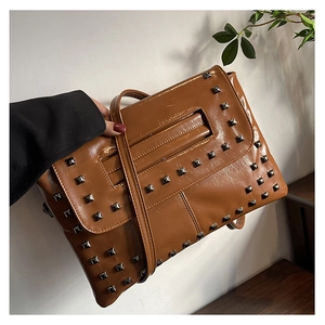 Dettaglio della borsa a busta in pelle PU marrone con borchie quadrate in metallo