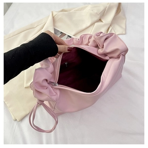 Detail view of the spacious purple interior and inner zip pocket of this pink baguette bag