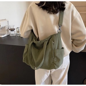 Detail view of olive green corduroy tote bag featuring adjustable woven wide strap