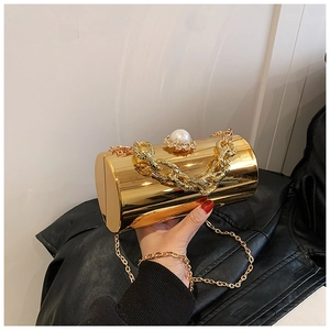 Detail of gold mirror cylinder clutch with pearl clasp and chunky metal chain
