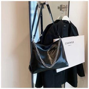 Detailed view of black wrinkled PU leather tote bag with silver chain and long shoulder strap