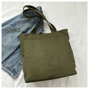 Detail view of olive green canvas tote bag showing stitching and side pocket design