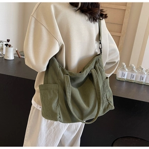 Detail of olive green corduroy tote bag with side pocket and adjustable shoulder strap