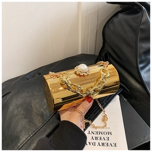 Macro detail of gold mirrored evening clutch with pearl clasp and rhinestone accents