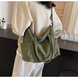 Detail of olive green corduroy tote bag showing ribbed texture and shoulder strap