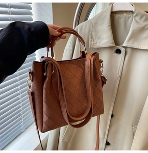 Detail of dark brown lychee grain PU leather bucket bag with quilted rhombic pattern stitching