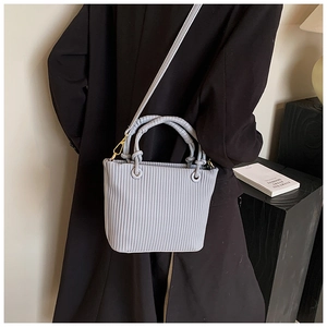 Close-up of vertical pleated texture on light blue PU leather bucket bag with gold hardware