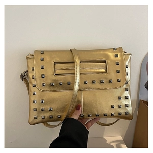 Dettaglio di pochette a busta dorata con borchie quadrate argentate e pelle testurizzata