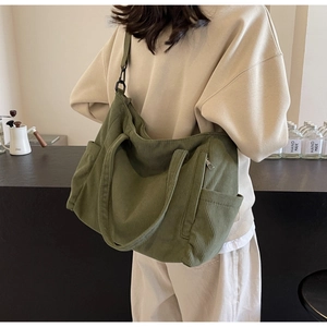 Olive green corduroy tote bag showing side storage pocket and adjustable shoulder strap