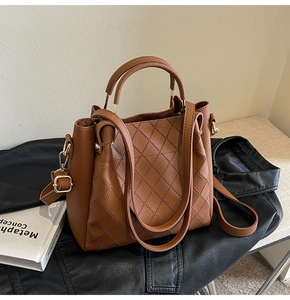 Close-up of brown bucket bag showing lychee grain texture and diamond stitching detail