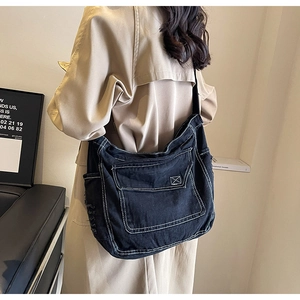 Dettaglio borsa shopper in denim nero con cuciture a contrasto e tasca frontale