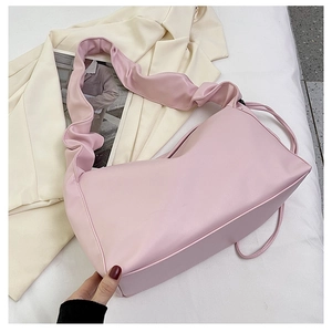Close-up of pink ruched shoulder bag with ruffle strap and smooth faux leather texture