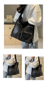 Detail view of black corduroy tote with signature heart-shaped zipper pockets and long straps