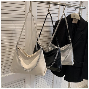 Close-up of soft leather tote bag featuring a chunky silver chain and pleated texture detail