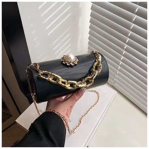 Detail of acrylic mirror cylinder bag with pearl clasp and chunky gold chain handle