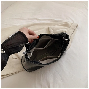 Interior view of black faux leather tote bag showing large capacity and inner pockets