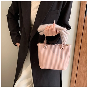 Detail showing pink bucket bag with vertical pleated texture and round handle rings