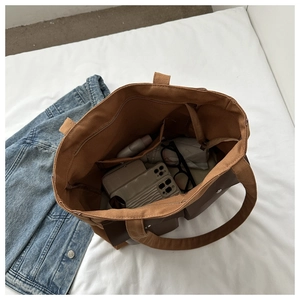 Interior view of brown canvas tote bag showing multiple pockets and spacious capacity