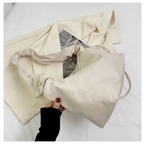 Detail of soft cream pleated shoulder strap and smooth faux leather texture of the bag