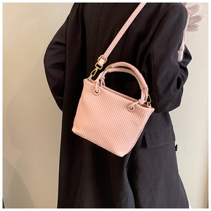 Pink pleated bucket bag with vertical stripe texture and round woven handle detail