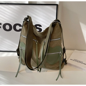 Detail shot of vintage green corduroy backpack with heart shaped pockets and silver zippers