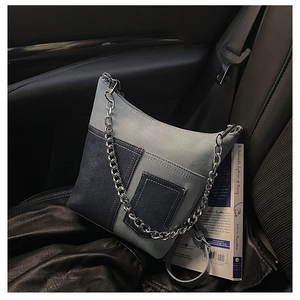 Detail of blue denim patchwork shoulder bag with silver chain strap on car seat