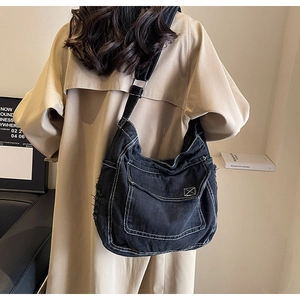 Dettagli della borsa in tela nera con cuciture bianche a contrasto e texture sfrangiata