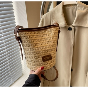 Detailed close-up of woven straw texture and leather trim on a bucket bag
