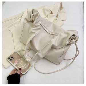 Top-down view of cream pleated tote bag with smooth leather texture and straps