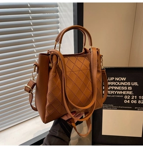 Detail of caramel leather bucket bag featuring quilted diamond pattern and sturdy top handles