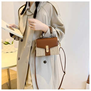 Detail der Crossbody Strohhandtasche mit brauner Lederklappe und goldenem Drehverschluss