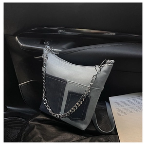 Close-up of a blue patchwork canvas bucket bag with chunky silver chain and strap