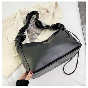 Detail of black soft leather hobo bag with pleated handle on a neutral background