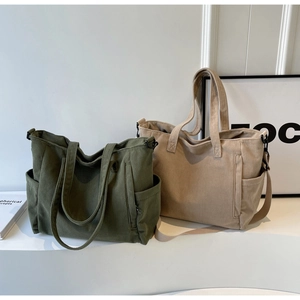 Detail of corduroy tote bags in olive green and khaki with functional side pockets