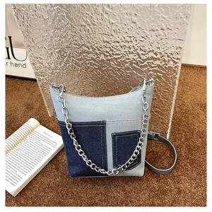 Detail of vintage patchwork denim bucket bag with metal chain and front pockets
