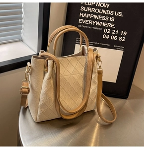 Detail of lychee pattern leather tote with quilted stitching and golden hardware