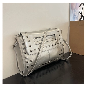 Dettaglio di una borsa a tracolla argento con borchie metalliche quadrate industriali