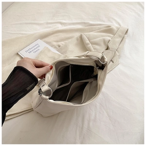 Interior view of beige leather tote showing gray lining with zipper pocket and dual slots