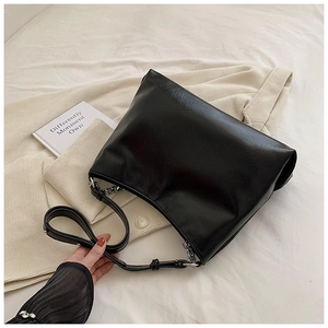 Detail view of black PU leather shoulder bag with silver chain and adjustable strap