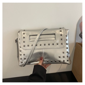 Dettaglio di una borsa a tracolla argento metallizzato con borchie quadrate in metallo