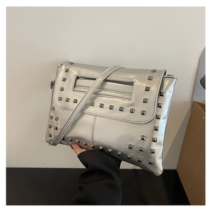 Dettaglio della borsa a tracolla argento con borchie metalliche quadrate e manico