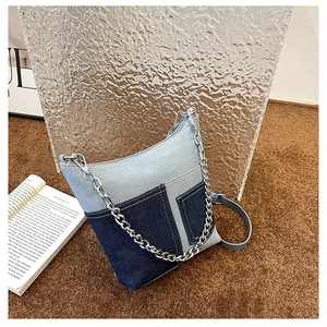 Detail view of patchwork denim crossbody bag with silver chunky chain and adjustable strap