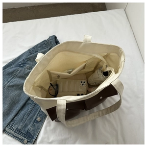 Top view of cream canvas tote bag showing spacious interior with phone, glasses and umbrella