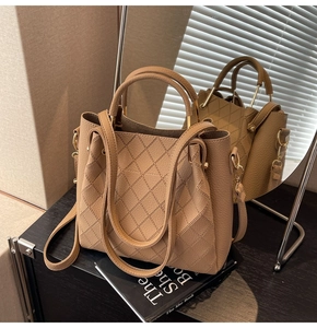 Detailed view of the khaki woven leather bucket bag with elegant golden hardware accents