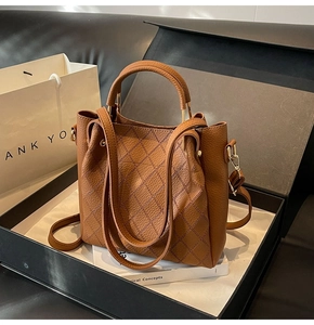 Brown quilted leather bucket bag with gold hardware in an elegant gift box presentation