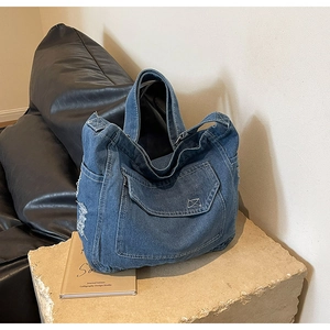 Dettaglio della borsa tote in denim con bordi sfrangiati e trama della tasca frontale