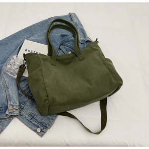Detail of dark green corduroy tote bag with side pockets and adjustable strap